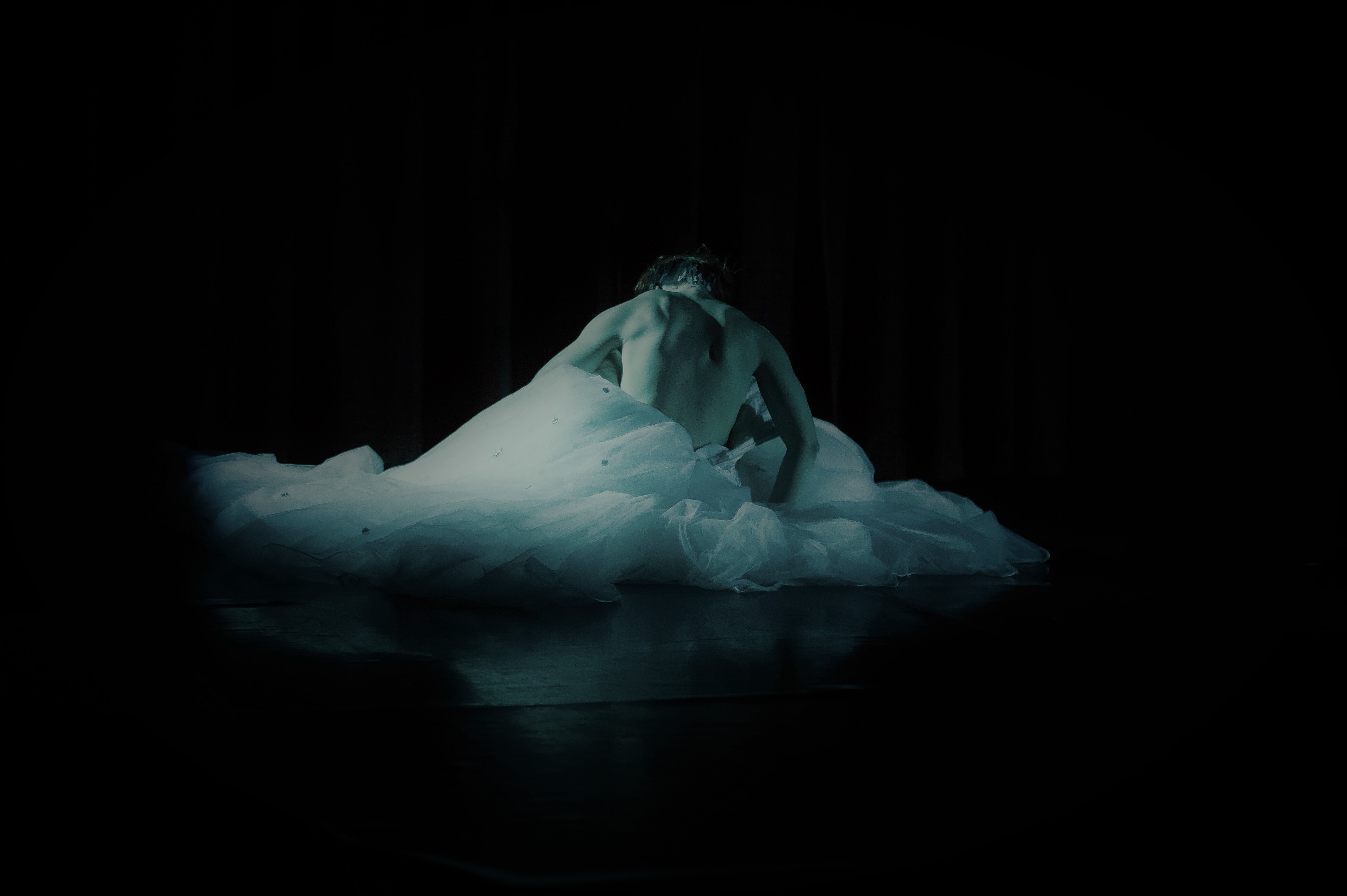 female dancer's back moving out of a white dress