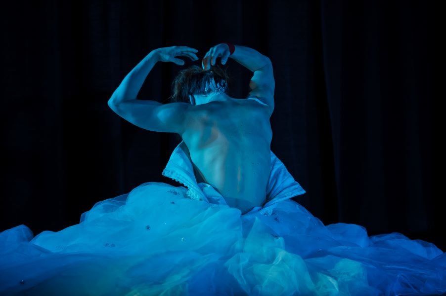 female dancer's back moving out of a white dress
